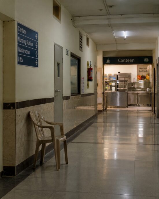 An empty chair in a quiet hospital corridor, reflecting on people who quietly disappear from our everyday lives.